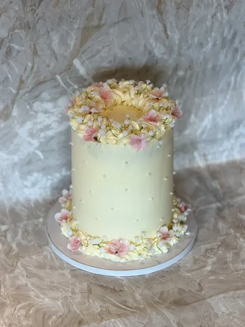 Hvit kake med blomsterkrans