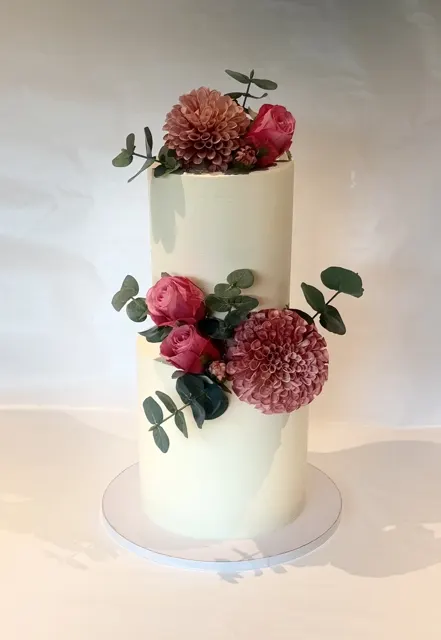 Høy kake i to etasjer med blomster